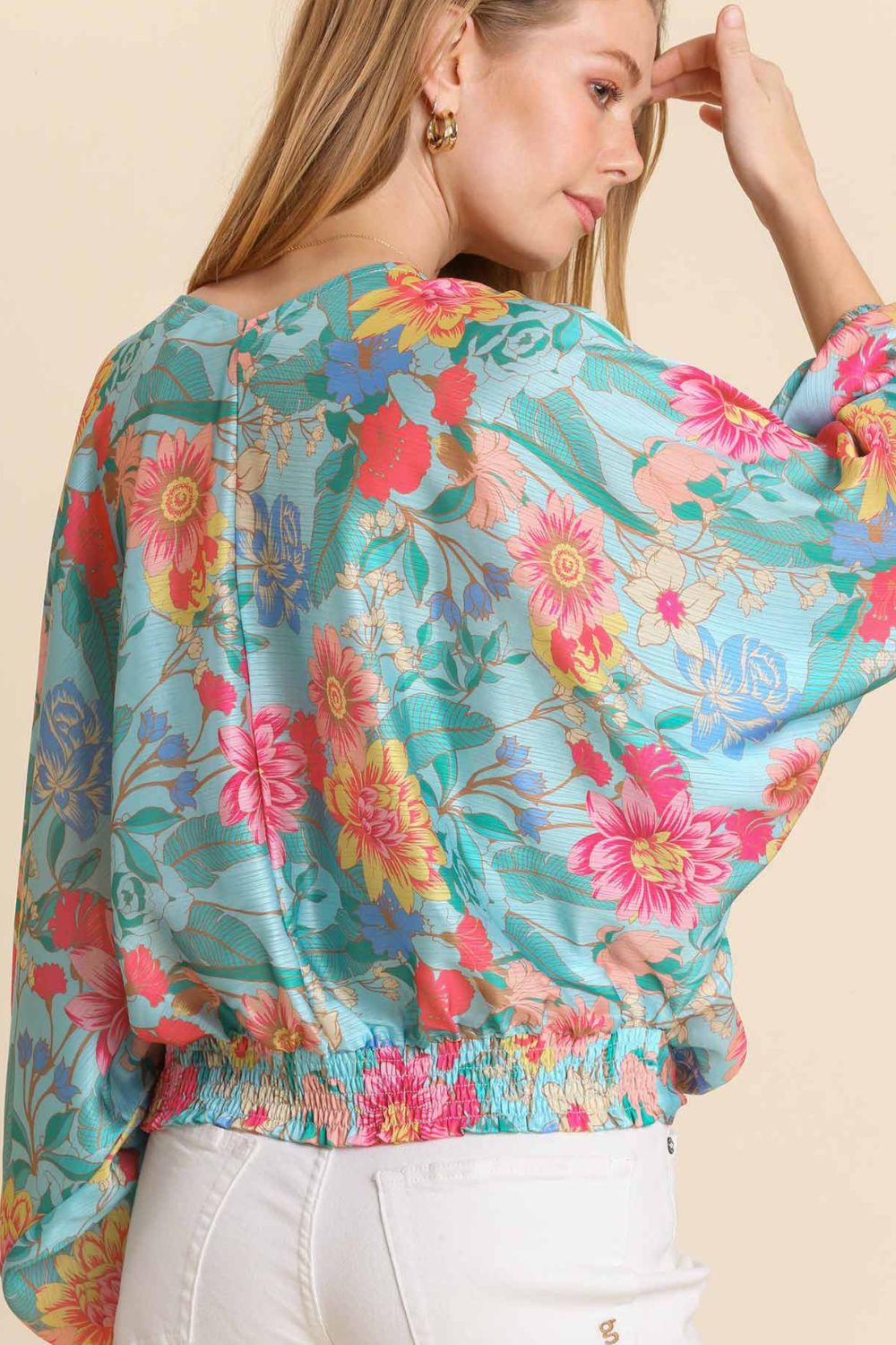 Elegant floral print blouse with a flattering V-neckline and smocked back hem, perfect for a feminine and stylish look.