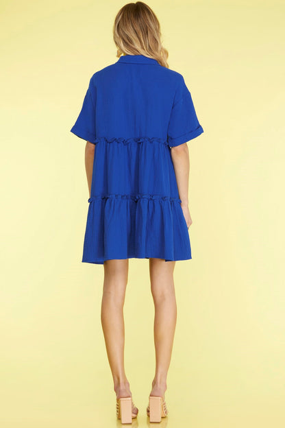 Chic button-front mini dress with frill detailing and tiered layers for a stylish and feminine look.