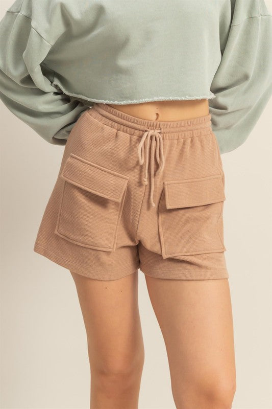 Drawstring waffle knit front pocket shorts in a soft, cozy fabric with an adjustable waist and functional pockets.