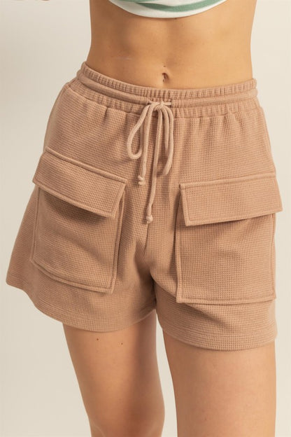 Drawstring waffle knit front pocket shorts in a soft, cozy fabric with an adjustable waist and functional pockets.