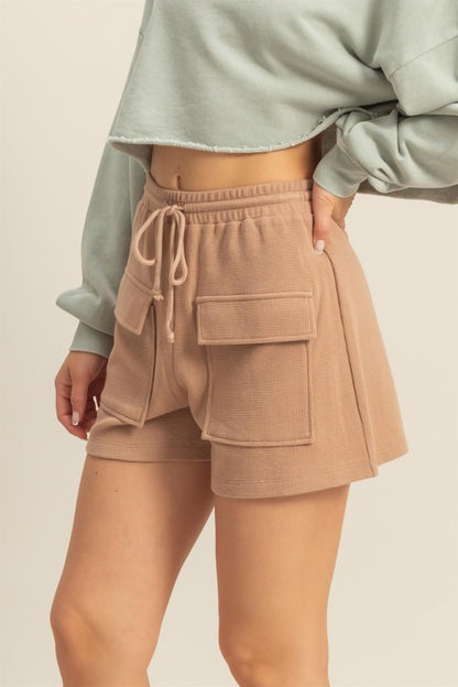 Drawstring waffle knit front pocket shorts in a soft, cozy fabric with an adjustable waist and functional pockets.