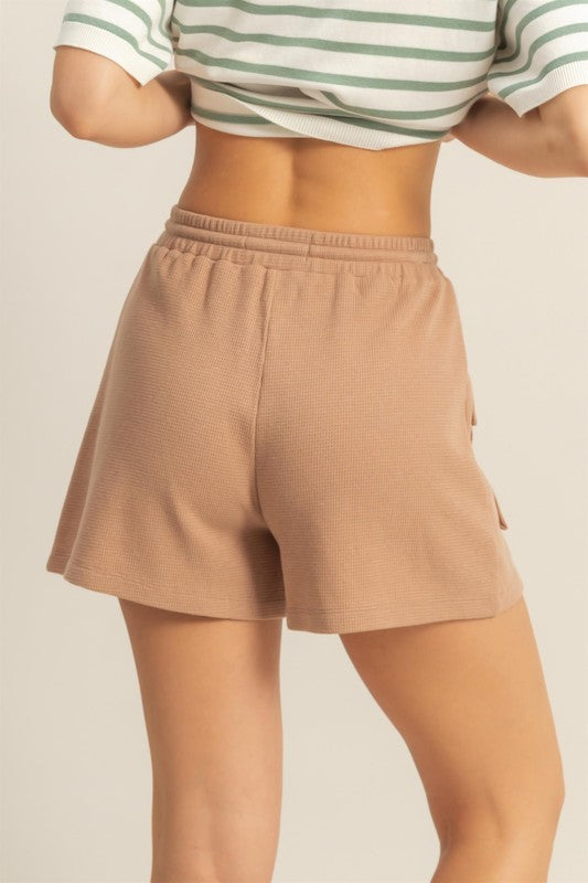 Drawstring waffle knit front pocket shorts in a soft, cozy fabric with an adjustable waist and functional pockets.