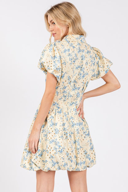 Floral eyelet mini dress with puff sleeves and a zipper front closure, designed for a chic and feminine look.