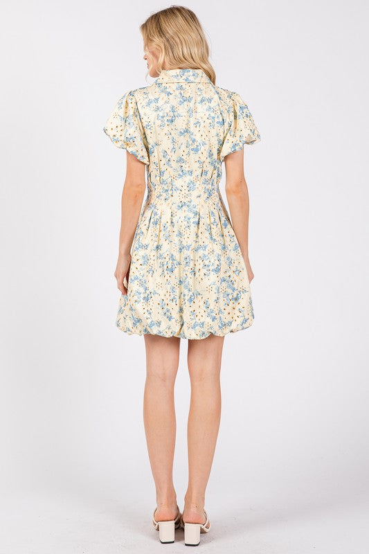 Floral eyelet mini dress with puff sleeves and a zipper front closure, designed for a chic and feminine look.