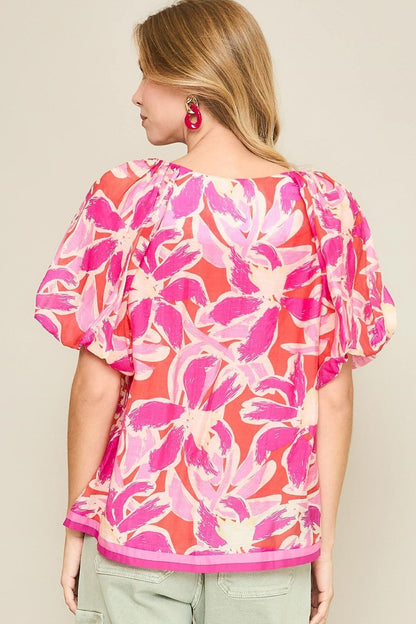 Floral blouse with notched neckline and puff sleeves, perfect for adding feminine charm to both casual and dressy looks.