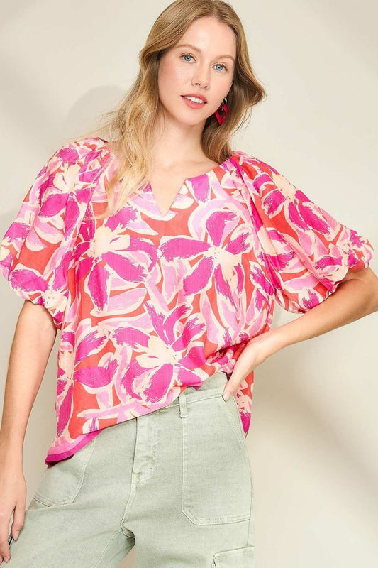 Floral blouse with notched neckline and puff sleeves, perfect for adding feminine charm to both casual and dressy looks.