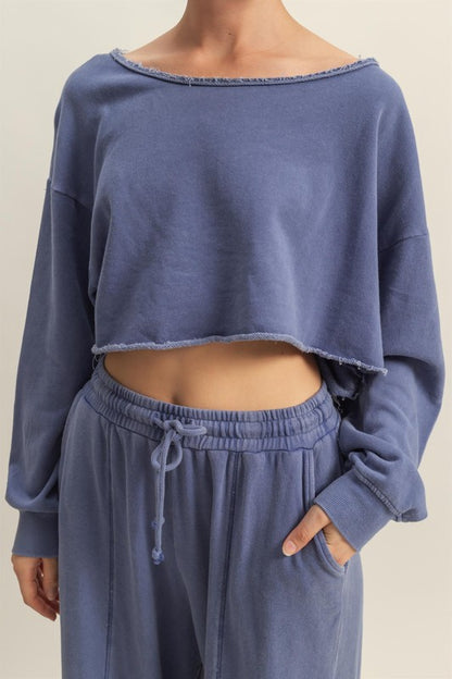 Trendy frayed detail boat neck long sleeve crop top, featuring a stylish distressed hem and modern silhouette.