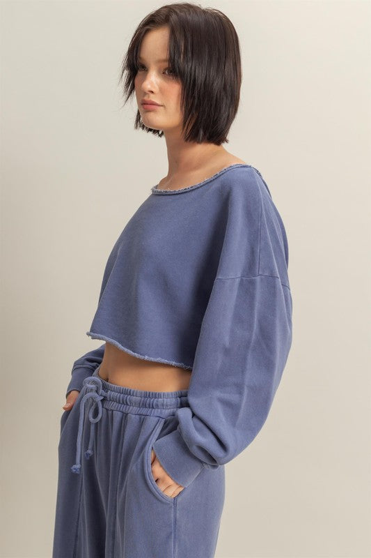 Trendy frayed detail boat neck long sleeve crop top, featuring a stylish distressed hem and modern silhouette.