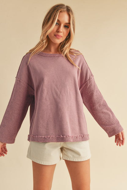 Stylish frayed edge round neck sweatshirt with a raw hem detail, perfect for a casual and modern look.