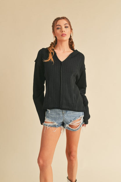 Trendy frayed hem exposed seam long sleeve hoodie with a modern distressed design, perfect for casual wear.