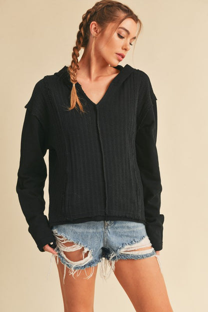 Trendy frayed hem exposed seam long sleeve hoodie with a modern distressed design, perfect for casual wear.