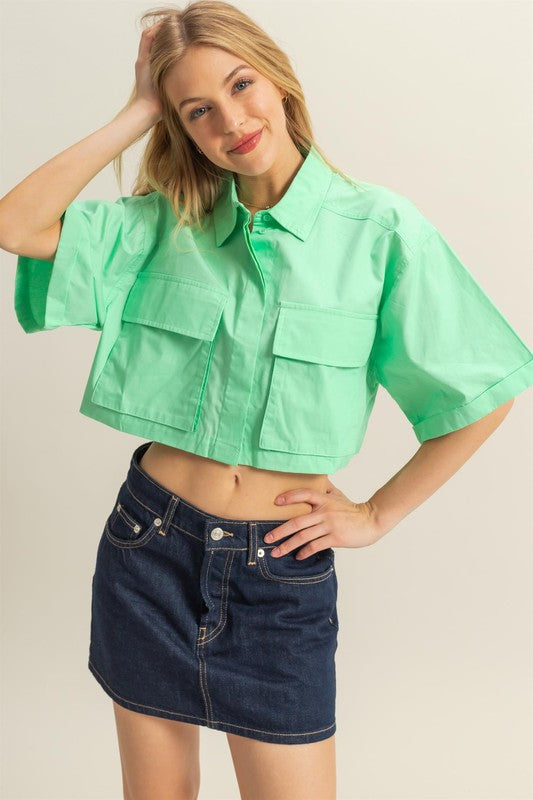 Trendy poplin collared crop shirt with front pockets, featuring a modern and structured design.