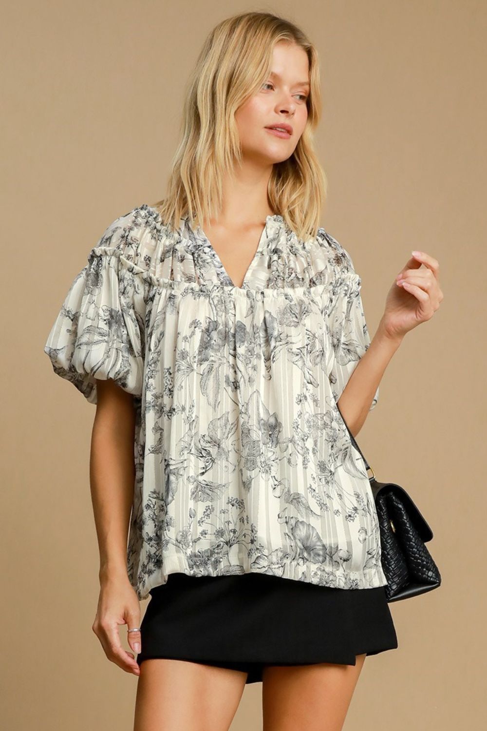 Floral print blouse with metallic accents and ruffle details, designed for a feminine and polished plus-size outfit.