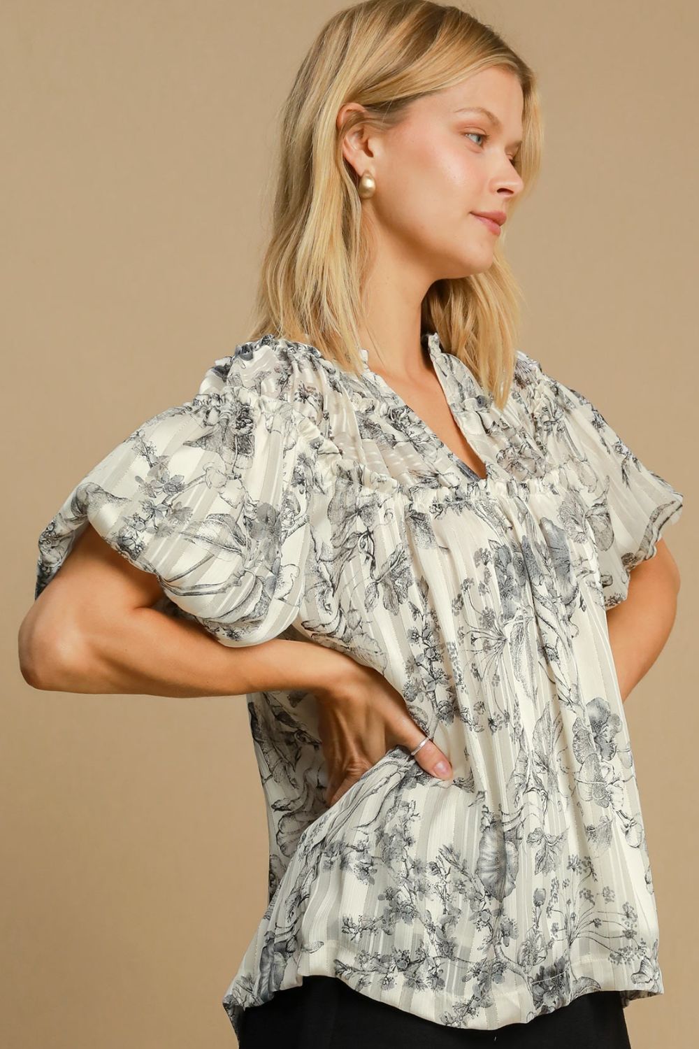 Floral print blouse with metallic accents and ruffle details, designed for a feminine and polished plus-size outfit.