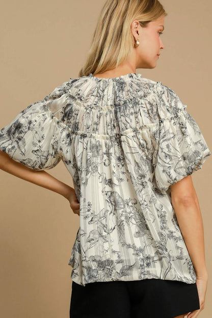 Floral print blouse with metallic accents and ruffle details, designed for a feminine and polished plus-size outfit.