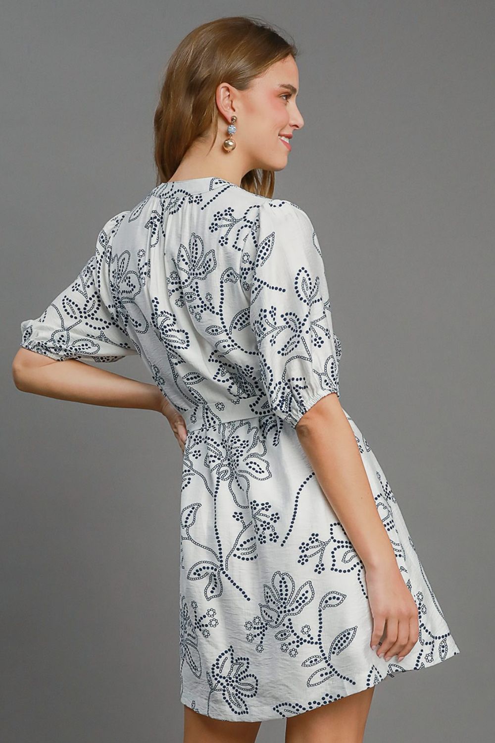 Charming floral print mini dress with puff sleeves and a stylish notched neckline, perfect for an elegant and feminine look.