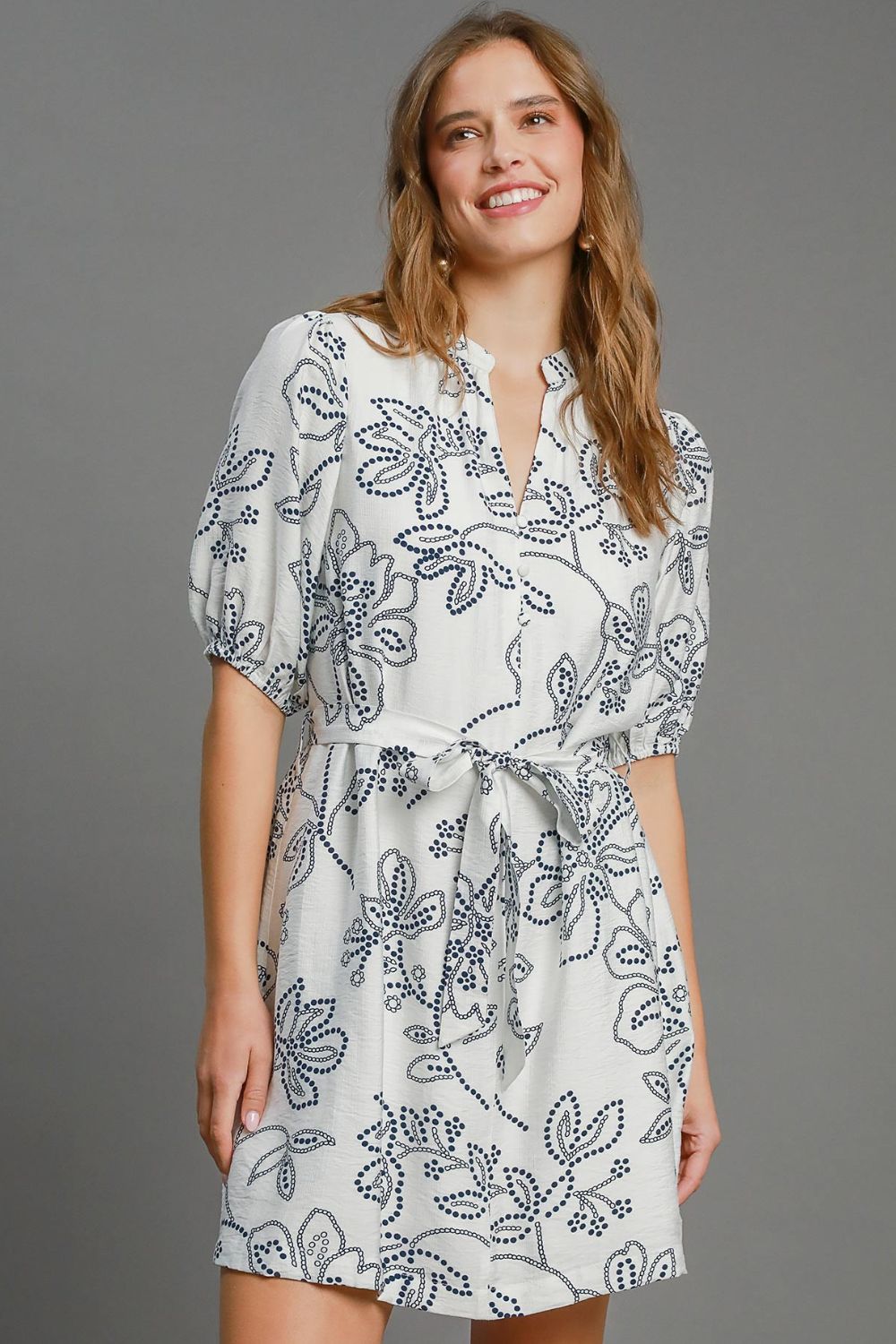 Charming floral print mini dress with puff sleeves and a stylish notched neckline, perfect for an elegant and feminine look.