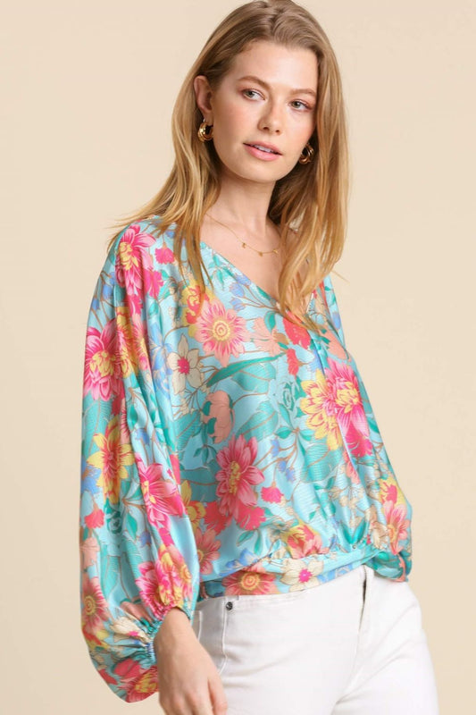 Elegant floral print blouse with a flattering V-neckline and smocked back hem, perfect for a feminine and stylish look.