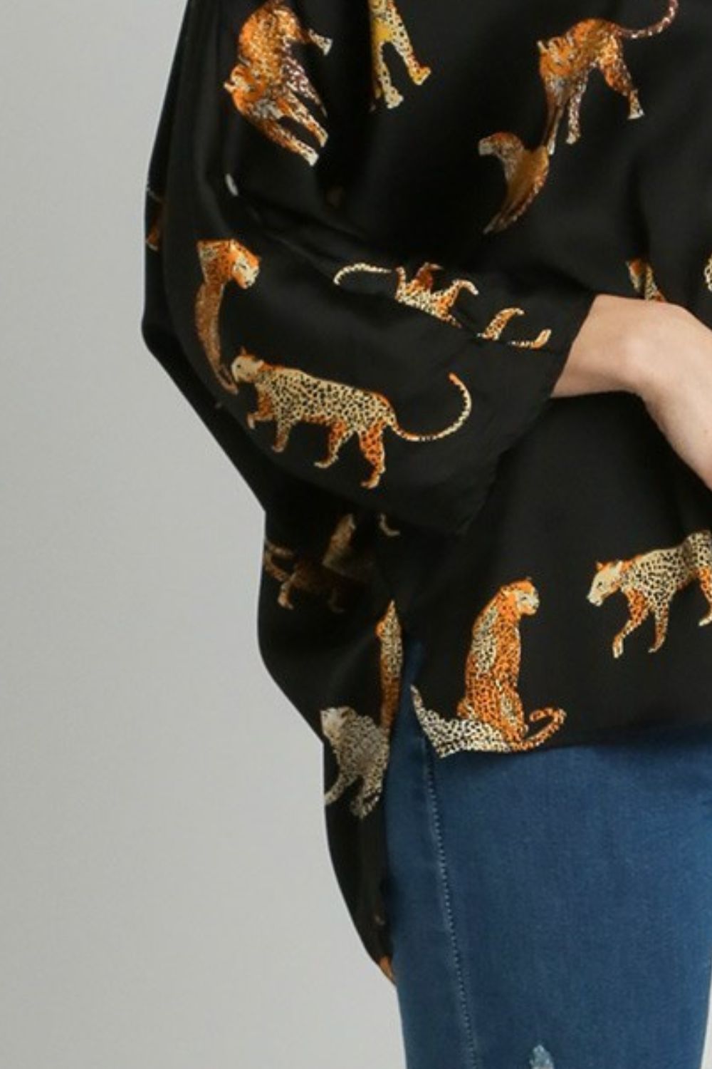 Bold high-low satin blouse with an animal print design and V-neckline, perfect for a chic and stylish look.