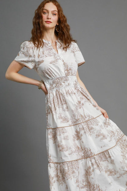 Bohemian-inspired landscape print maxi dress with a flowy tiered skirt and short sleeves, perfect for a romantic and elegant look.