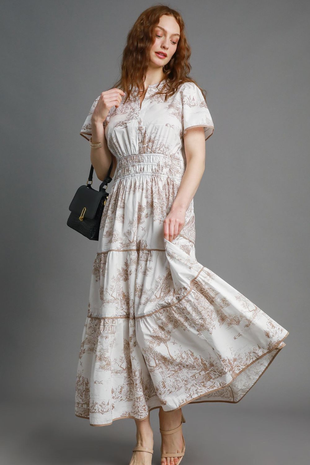 Bohemian-inspired landscape print maxi dress with a flowy tiered skirt and short sleeves, perfect for a romantic and elegant look.