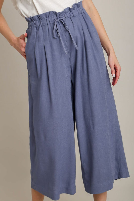 Linen wide-leg pants with drawstring and paperbag waist, designed for breathable comfort and relaxed plus-size style.