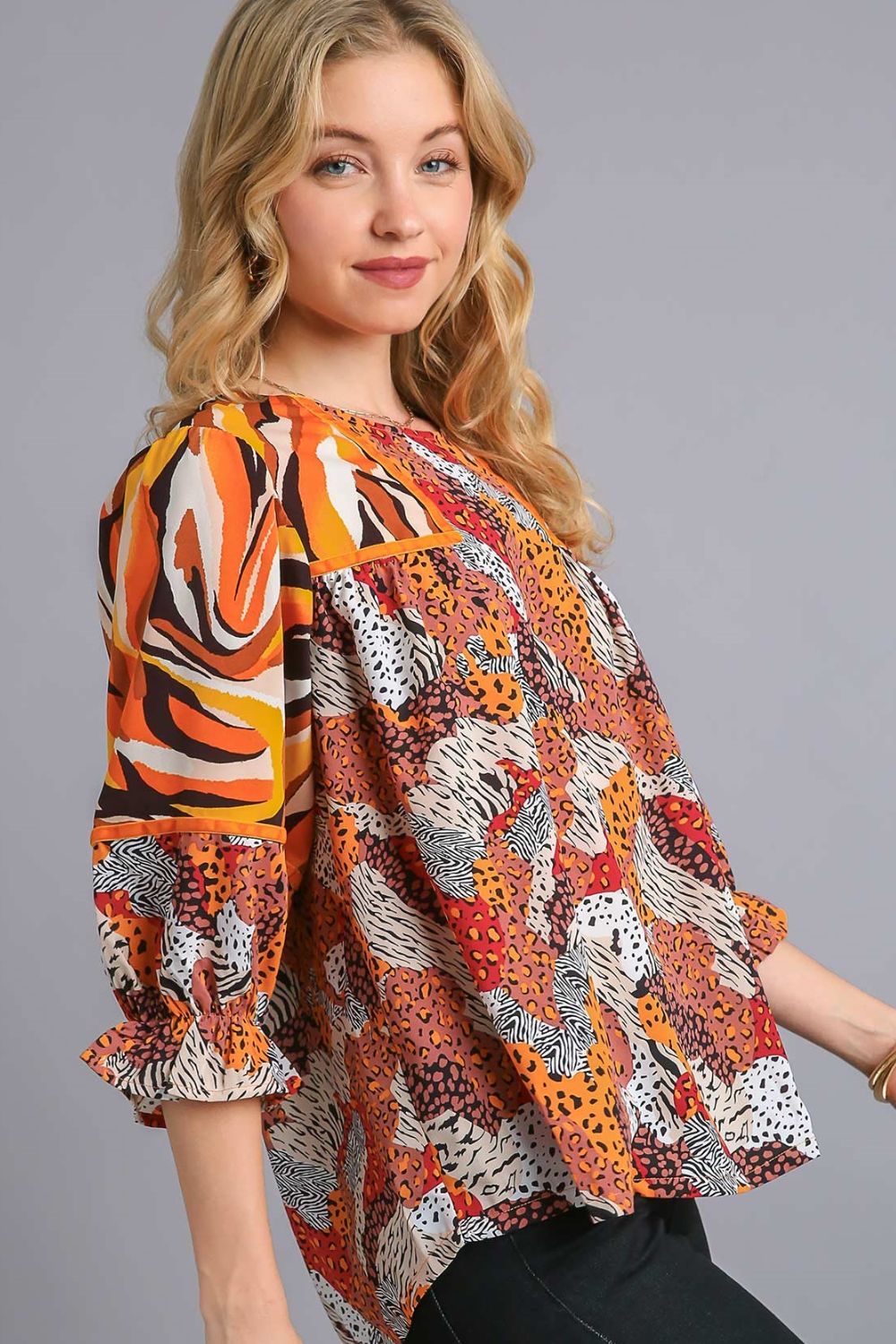 Stylish mixed print blouse with a classic round neckline and flouncy sleeves, perfect for a chic and trendy look.