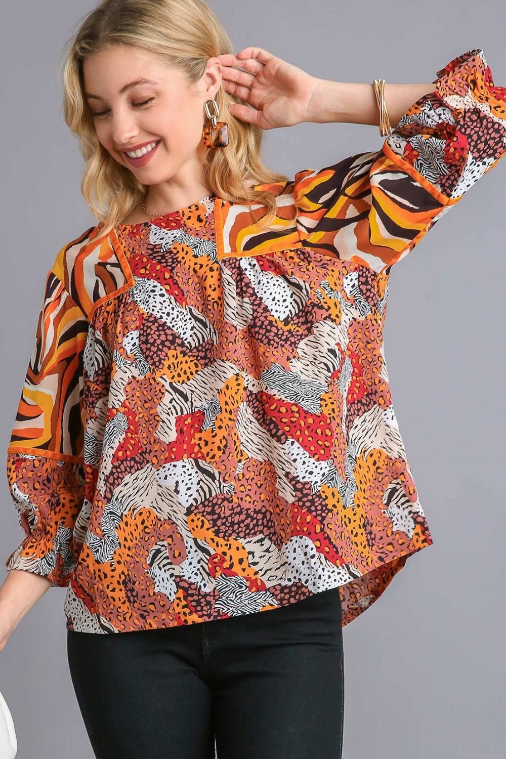 Stylish mixed print blouse with a classic round neckline and flouncy sleeves, perfect for a chic and trendy look.