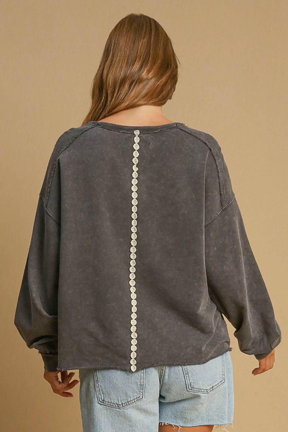 Stylish mineral wash sweatshirt with lace applique details and exposed seams, perfect for a cozy and fashionable look.