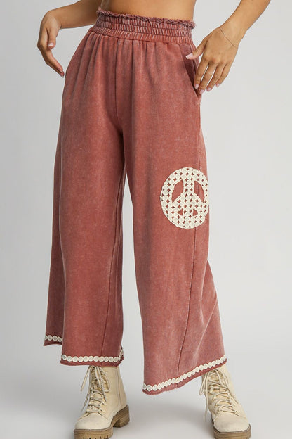 Stylish mineral wash wide-leg pants with lace applique details and a flowy, flattering silhouette, perfect for a chic and effortless look.