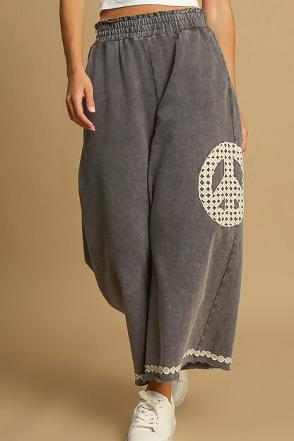 Stylish mineral wash wide-leg pants with intricate lace applique details, perfect for a boho-chic and elegant look.