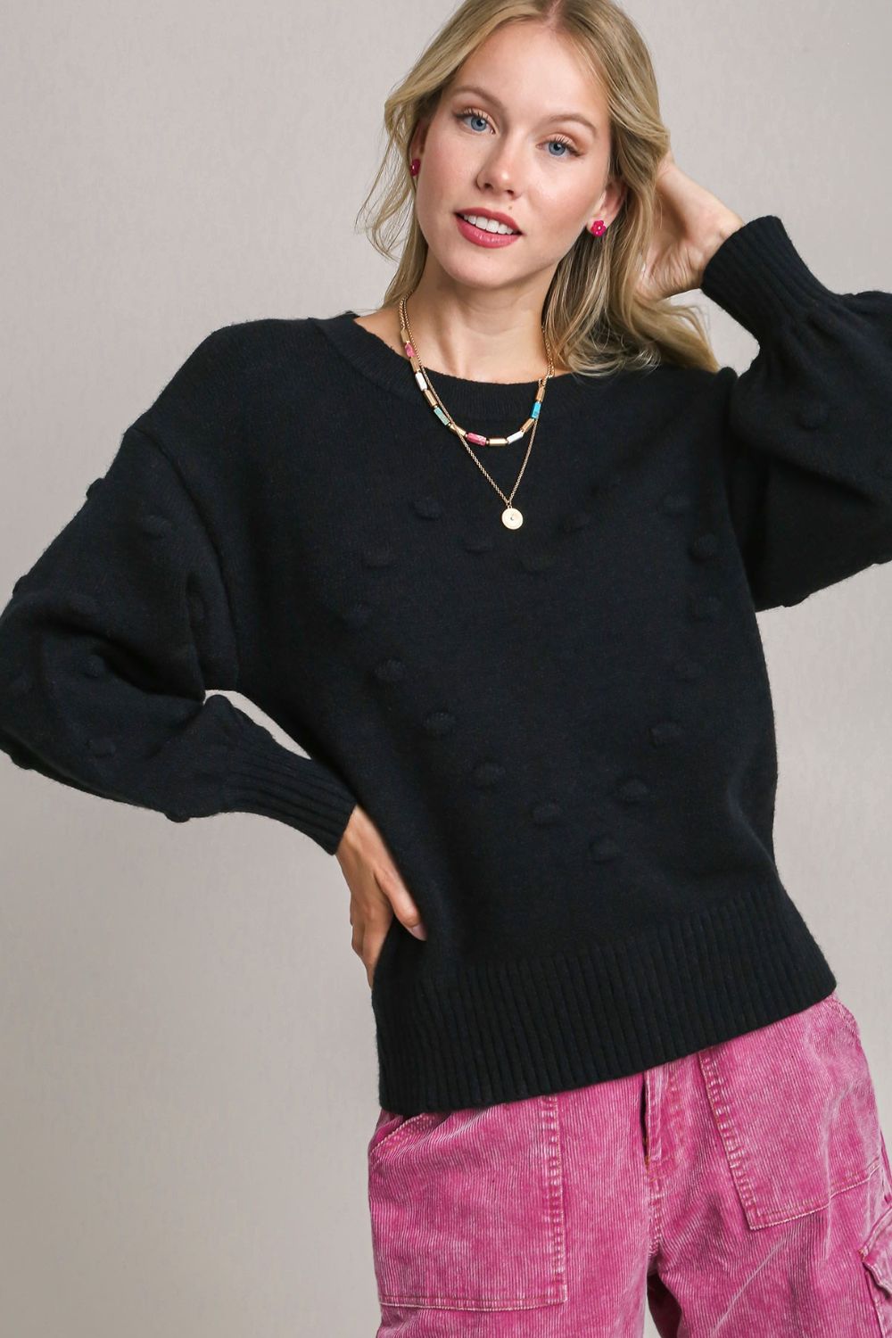 Cozy knit sweater with a playful pom pom heart design and a classic round neckline, perfect for a fun and stylish winter look.