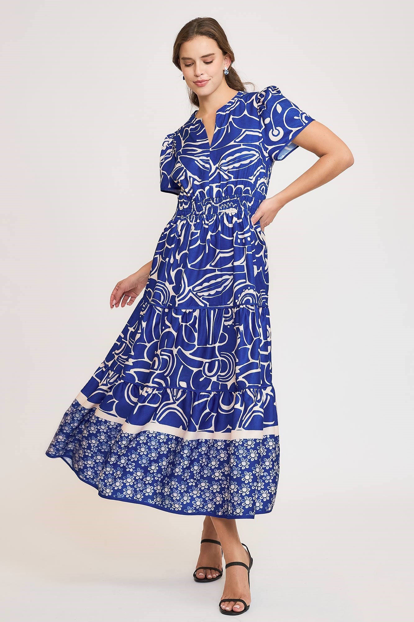 Elegant printed tiered dress with a notched neckline and short sleeves, perfect for a chic and feminine look.