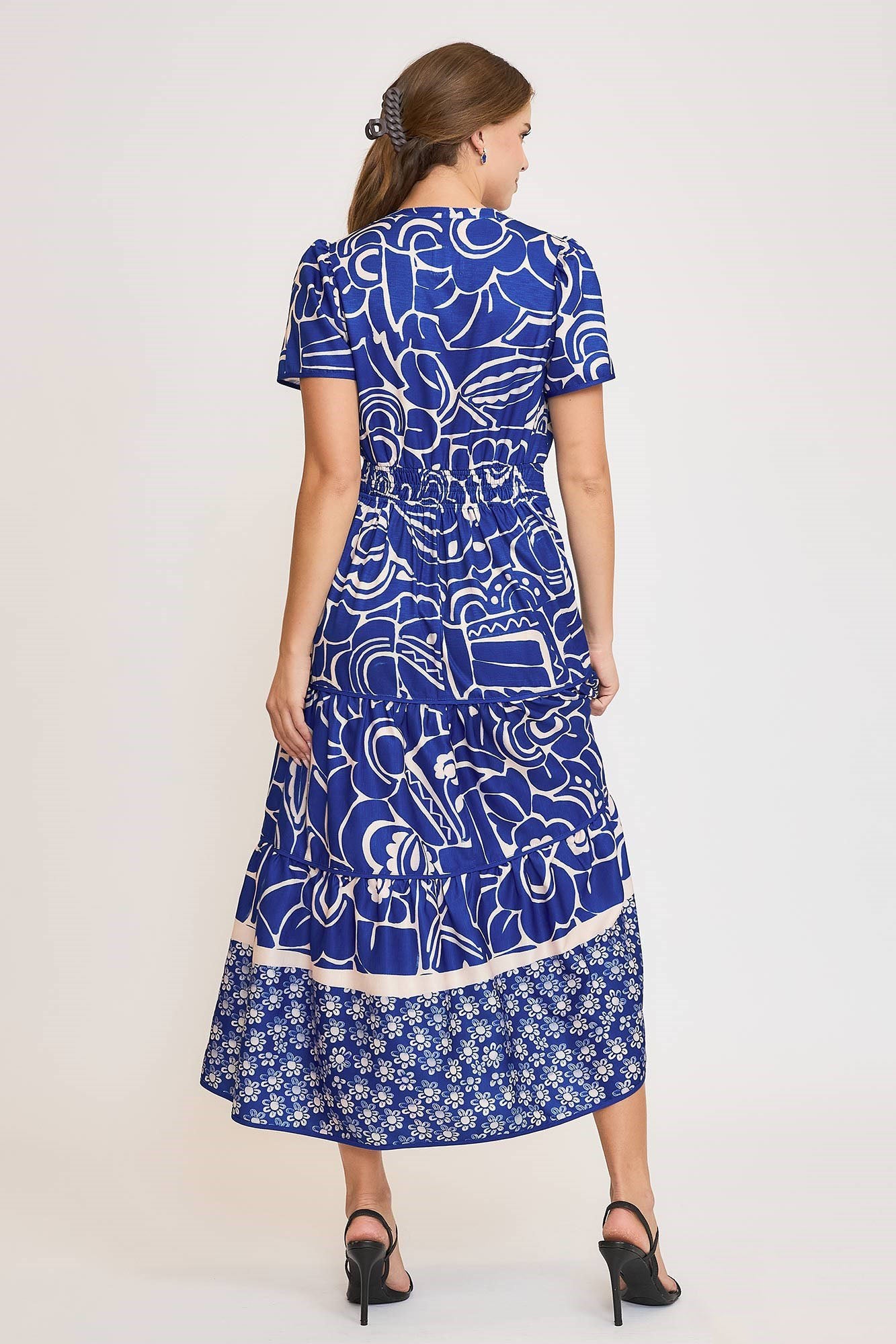 Elegant printed tiered dress with a notched neckline and short sleeves, perfect for a chic and feminine look.