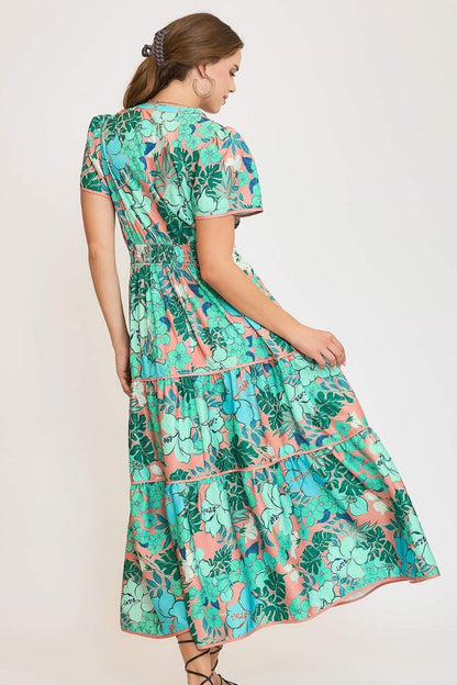 Elegant printed tiered dress with a notched neckline and soft short sleeves, perfect for a chic and feminine style.