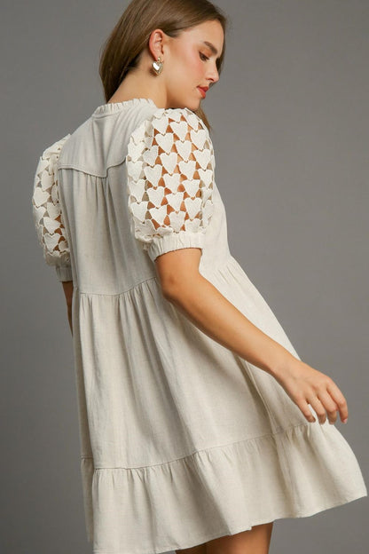 Elegant ruffled hem dress with heart lace sleeves and a tie neck, perfect for a feminine and romantic look.