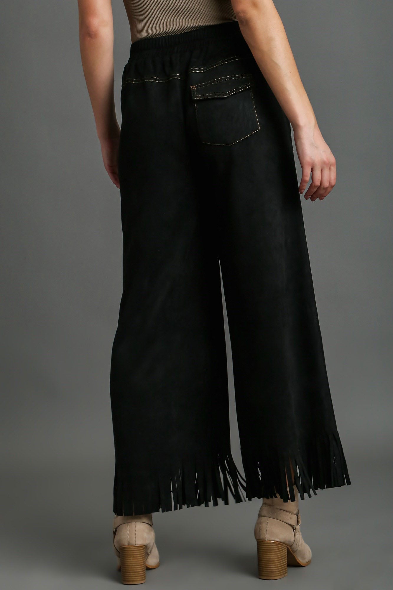 Stylish suede fringe hem wide-leg pants with a chic bohemian-inspired design, perfect for a statement look.