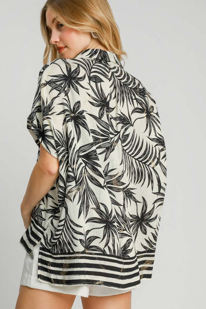 Vibrant tropical print button-down shirt with a high-low hem and side slits, perfect for a relaxed and stylish vacation look.