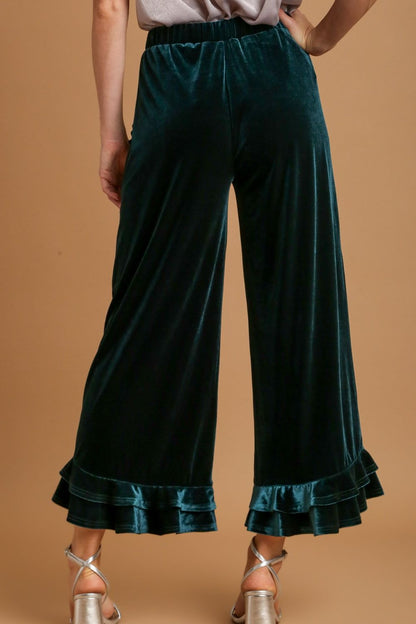 Elegant wide fit velvet pants with ruffle details and embroidered pockets, perfect for a chic and sophisticated look.