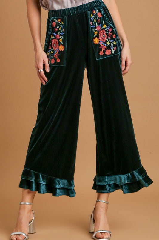 Elegant wide fit velvet pants with ruffle details and embroidered pockets, perfect for a chic and sophisticated look.