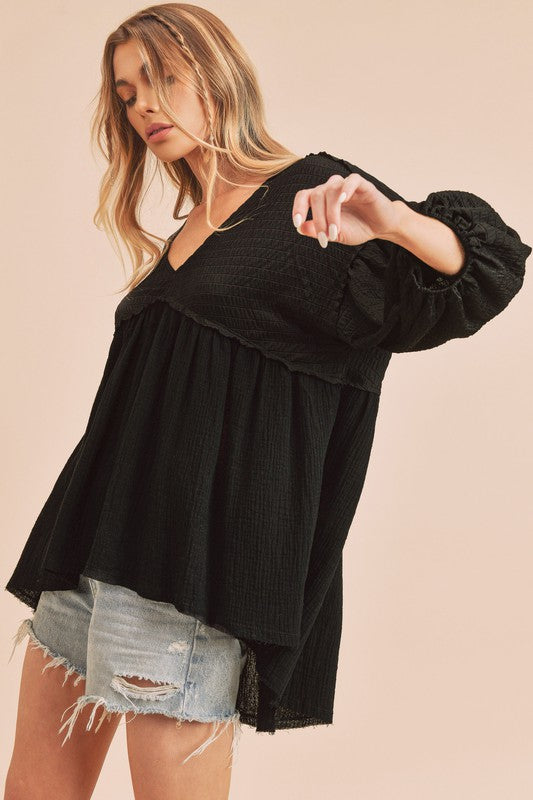 Trendy high-low V-neck blouse with frayed hem detailing, perfect for casual chic and semi-formal looks.