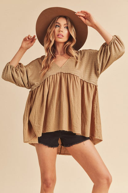 Stylish high-low frayed hem V-neck blouse with a modern and edgy design, perfect for versatile wear.