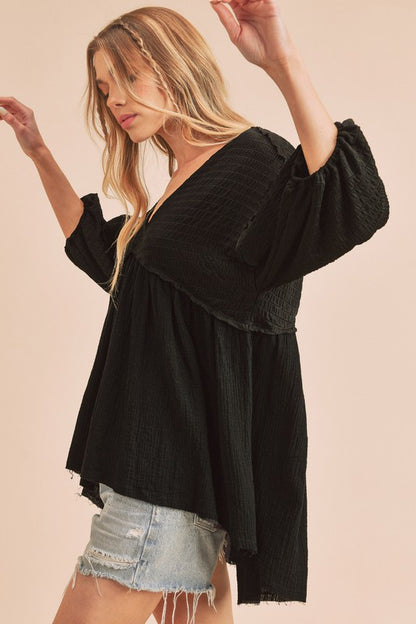 Trendy high-low V-neck blouse with frayed hem detailing, perfect for casual chic and semi-formal looks.