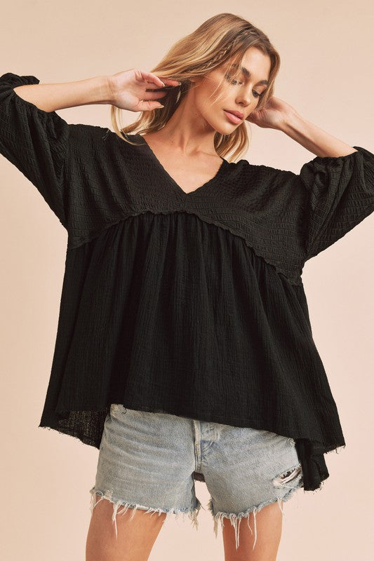 Trendy high-low V-neck blouse with frayed hem detailing, perfect for casual chic and semi-formal looks.