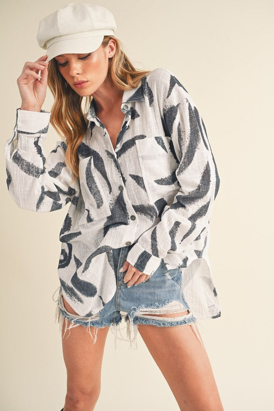 Stylish high-low button-up long sleeve shirt with a printed design, perfect for a trendy and versatile look.