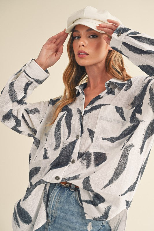 Stylish high-low button-up long sleeve shirt with a printed design, perfect for a trendy and versatile look.