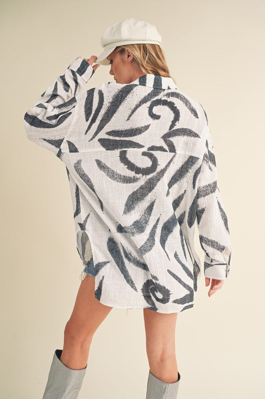 Stylish high-low button-up long sleeve shirt with a printed design, perfect for a trendy and versatile look.