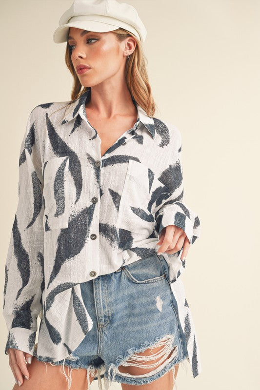 Stylish high-low button-up long sleeve shirt with a printed design, perfect for a trendy and versatile look.