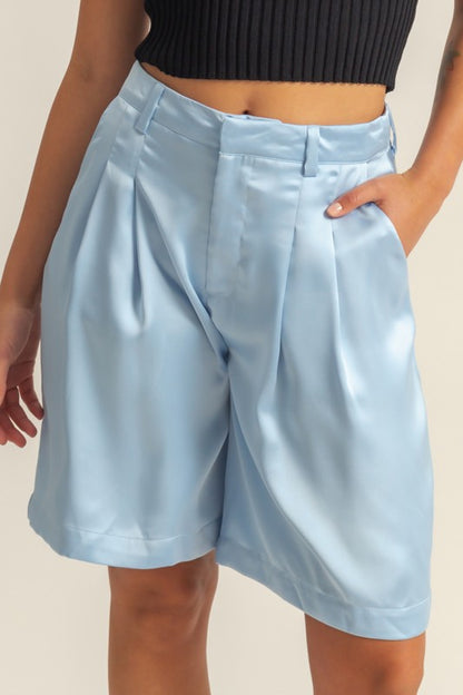 Elegant high-waist pleated satin shorts with a chic silhouette and luxurious finish, perfect for dressy or casual looks.