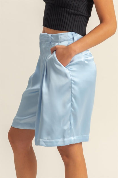 Elegant high-waist pleated satin shorts with a chic silhouette and luxurious finish, perfect for dressy or casual looks.